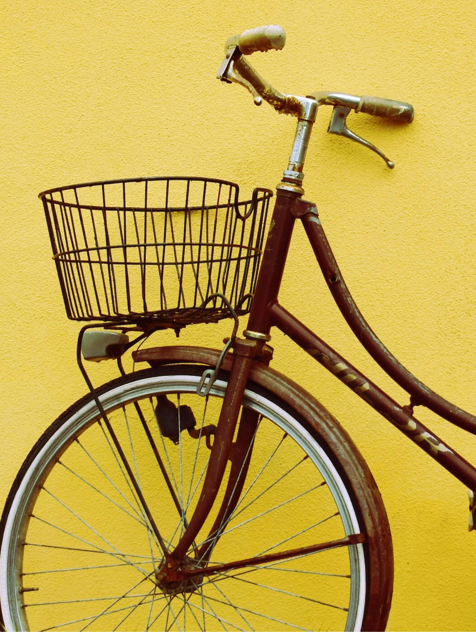 Bicycle leaning on a yellow wall