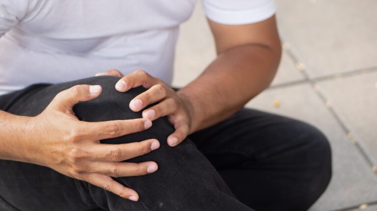 man holds knee after falling in retail store