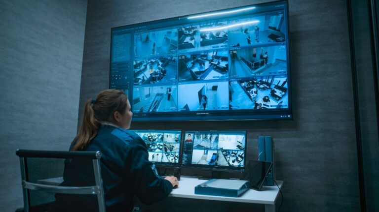 Female CCTV operator controls office surveillance cameras